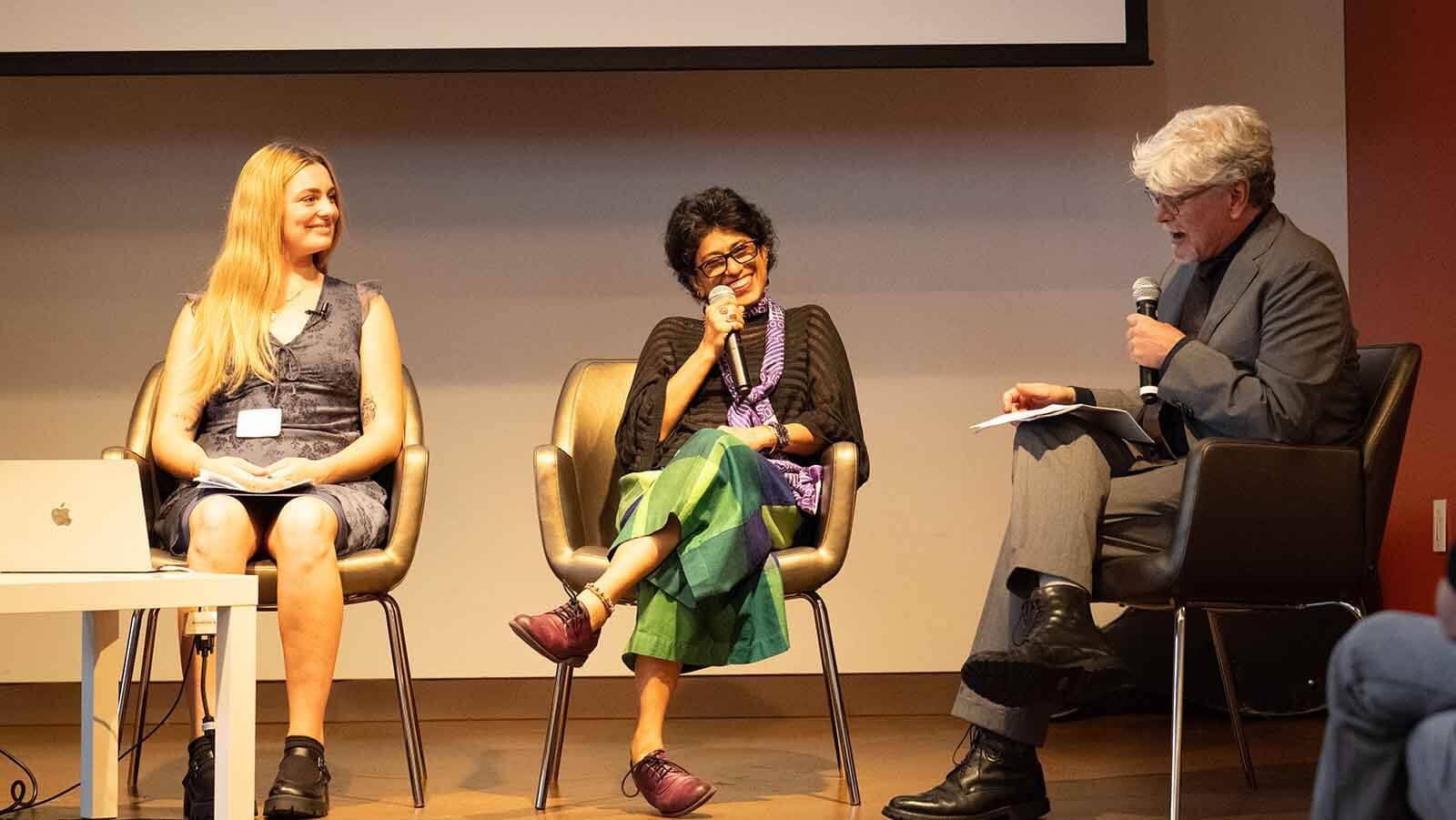 Co-curators speaking on a stage