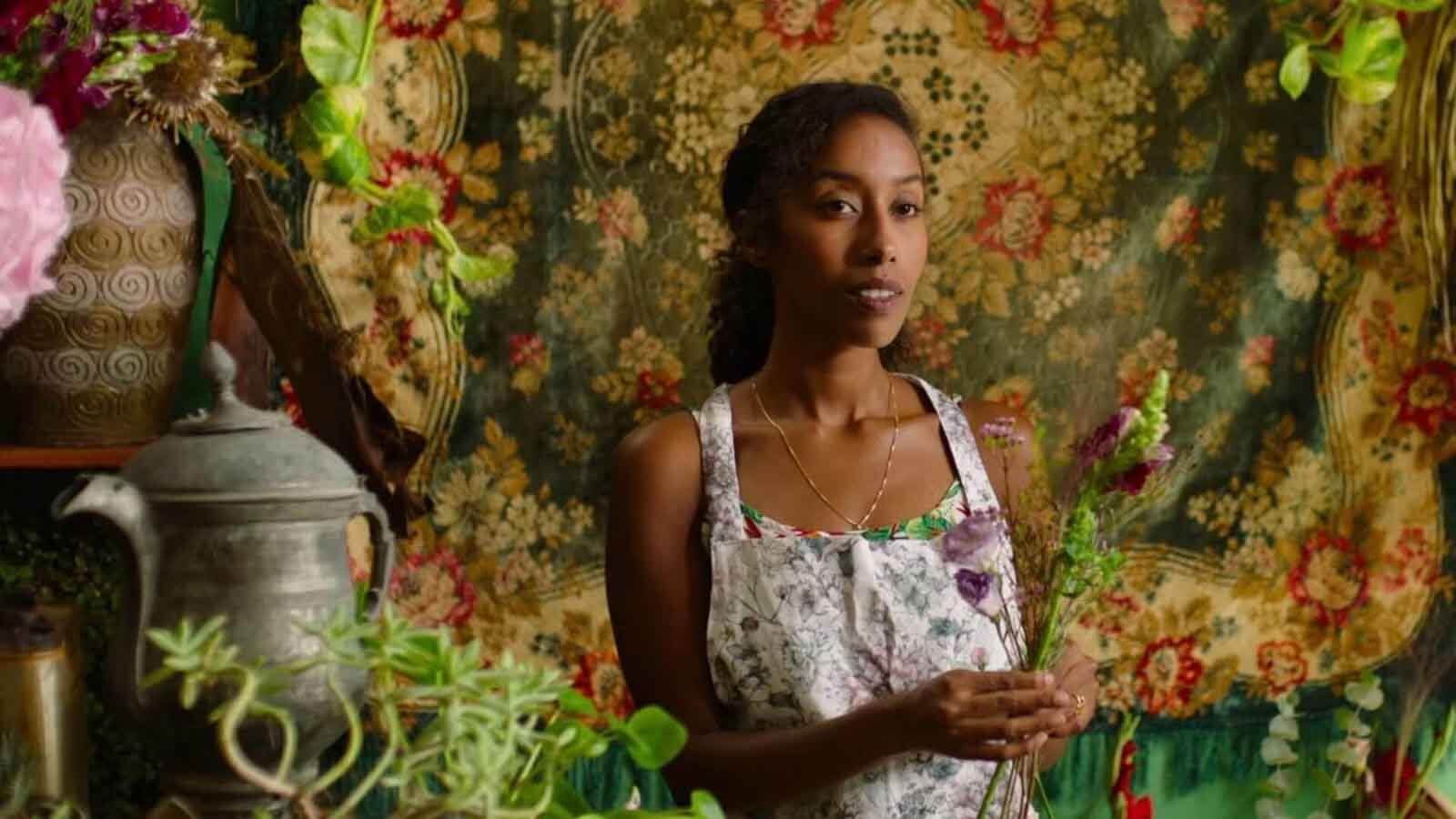 Woman with tapestry in background